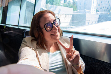 Smiling businesswoman making victory sign while riding subway. Concept of inclusion, adapted public
