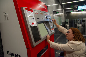 Woman buying subway ticket at ticket machine. Concept of inclusion, adapted public transport