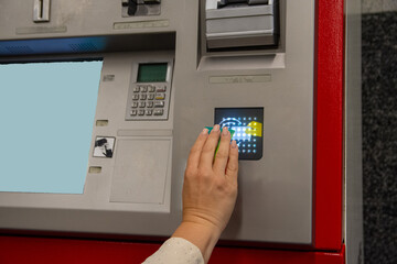 Woman using contactless payment on atm in subway station. Concept of inclusion, adapted public