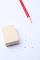 Eraser, pencil, doodle and scraps on white background, selective focus