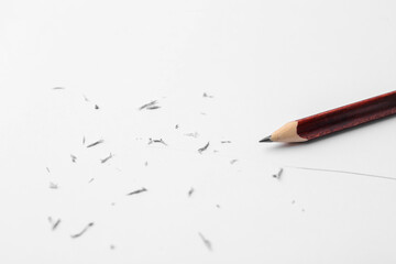 Graphite pencil and eraser shavings on paper sheet, closeup