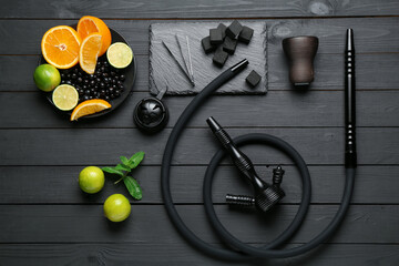 Hookah, coal and fresh fruits on black wooden table, flat lay