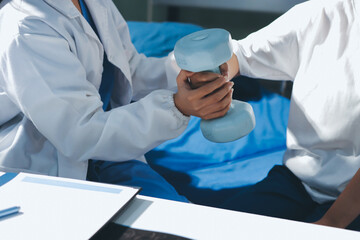 Unrecognizable uses blue hand weight during physical therapy session