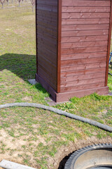 Wooden toilet and a pit for an outdoor village toilet with walls made of rubber tires. Installation of a toilet on a personal plot