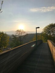 Wooden bridge at sunset overlooking a valley