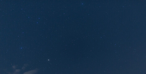 Panorama blue night sky milky way and star on dark background.Universe filled with stars, nebula and galaxy with noise and grain.Photo by long exposure and select white balance.Dark night sky.
