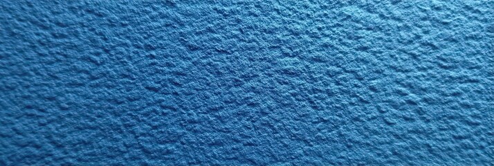 A detailed close-up of a textured blue surface with a rough, granular pattern resembling water or a stucco finish.