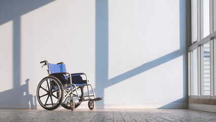 Empty Wheelchair on CobbleStone Tile Floor with Light and Shadow on Interior Wall Background in Rest Area at Hospital, Front view with Copy space