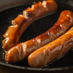 hot dogs are cooking in a hot cast iron pan
