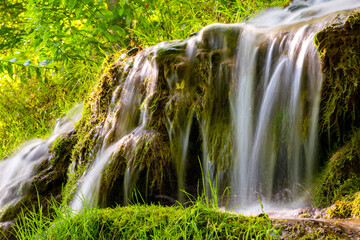 The Urach waterfall on the edge of the Swabian Alb is a high waterfall with tufa deposits. Detail with long exposure effect after heavy rain in summer. Popular tourist attraction in a natural reserve.