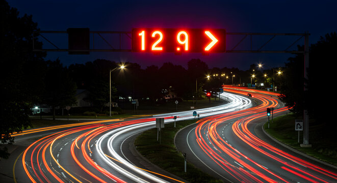 Time Exposure Image Of A Highway At Night With Speed Limit Display