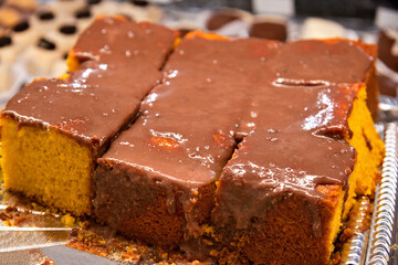 Carrot cake with chocolate, creamy frosting dripping over the top, typical Brazilian sweet at June...