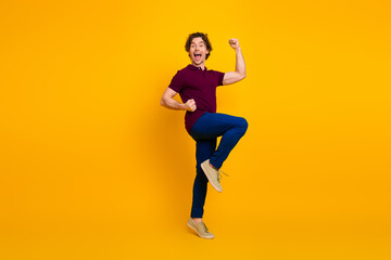 Excited young man in casual outfit celebrating and posing against bright yellow background with enthusiastic expression