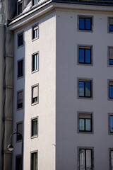 Modern apartment building with clean white facade and symmetrical windows. Vertical architectural...