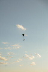 Paramotor, motorized parachute flying in the blue skies of a sunny day