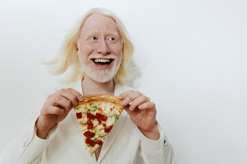 cheerful person holding a slice of pizza, smiling widely with blonde hair against a plain white...