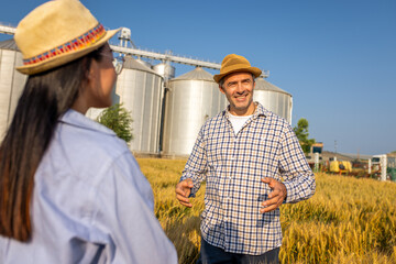  Two Silo Workers Standing in Wheat Field Discussing Future Tasks