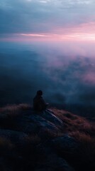 A person meditating alone on a hilltop at sunrise