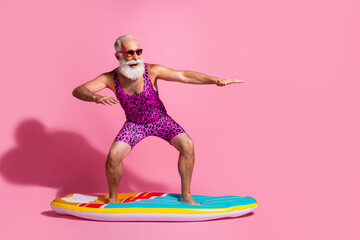 Photo of funny funky optimistic pensioner wear swimsuit resort surfing wave isolated on pink color background