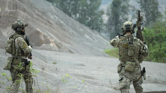 A special forces squad on patrol carefully navigates steep and difficult terrain in a barren mountainous region A concept for mountain warfare and endurance