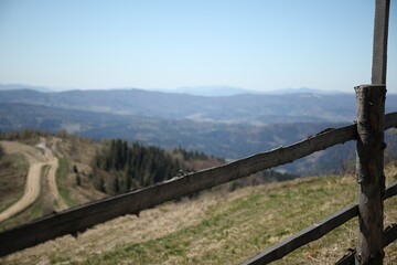Fototapeta premium Picturesque view of wooden fence near mountains and forest