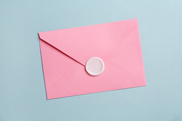 Beautiful invitation envelope with wax seal on grey background, top view