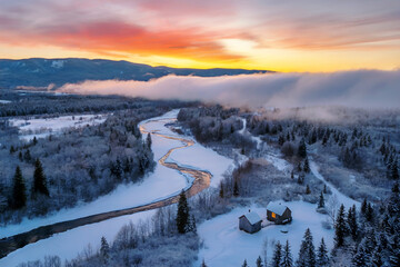 Winter Sunrise over a Snowy River and Cabins