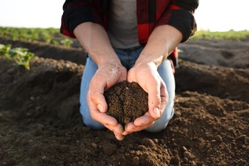 Man holding pile of soil in field, closeup