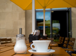 cup of coffee and sugar saker in a coffee shop, free copy space.Narrow depth of field.