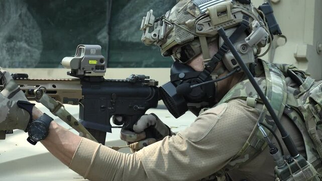 A special forces soldier equipped with a gas mask and advanced combat helmet stands guard by an armored vehicle A concept for CBRN defense and modern warfare readiness