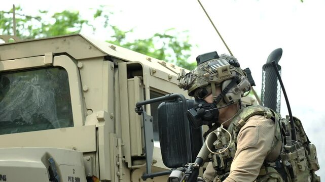 A special forces soldier equipped with a gas mask and advanced combat helmet stands guard by an armored vehicle A concept for CBRN defense and modern warfare readiness