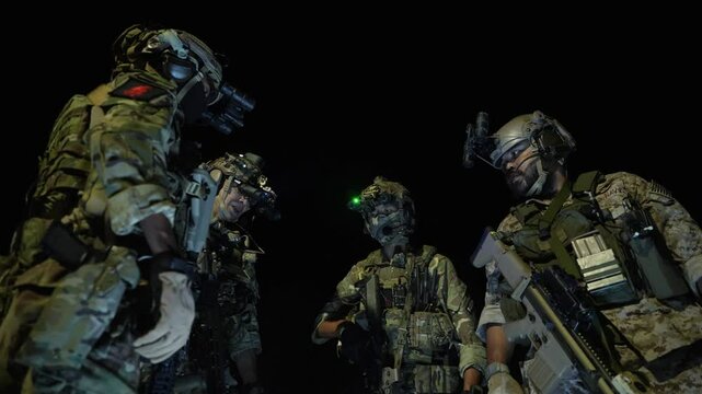 Special forces team gathers at night for a mission briefing, equipped with night vision goggles and tactical gear, ready for a stealth operation under darkness.