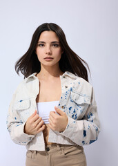 A stylish woman in a light denim jacket poses smiling