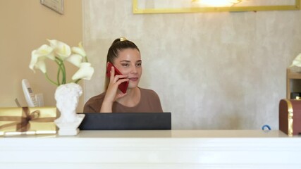 Beautician talking on phone at reception desk
