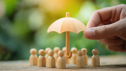 Hand holding a miniature umbrella over a group of wooden figurines
