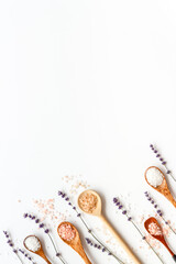 Obraz na płótnie Canvas Beauty spa therapy cosmetics and wellness flat lay - sea salt in many spoons with flowers, top view
