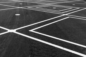 A detailed view of intersecting white lines on an asphalt surface,
