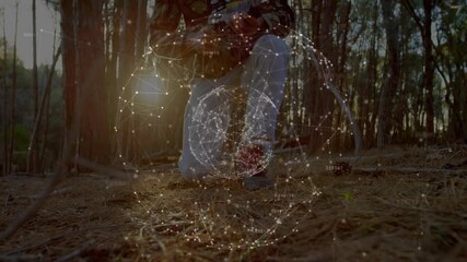 Archer kneeling in forest responding to rotating technology sphere, adjusting bow for soil study - Powered by Adobe