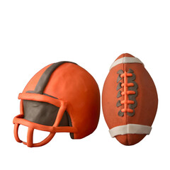 An orange and brown clay model of an american football helmet and ball is isolated on transparent background