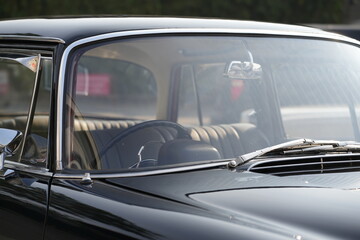Fototapeta premium The windshield and chrome wipers of a classic car showcase the timeless allure of vintage automotive design, with their glossy finish and detailed craftsmanship sparking nostalgia for a past era.