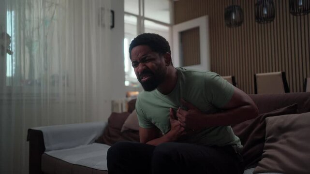 Young black man suffering chest pain at home, possible heart attack