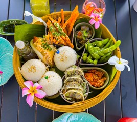 A vibrant top-down view captures an elaborately arranged Asian appetizer platter served in a round...