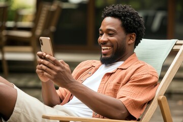 Happy man relaxing outdoors, using his cellphone