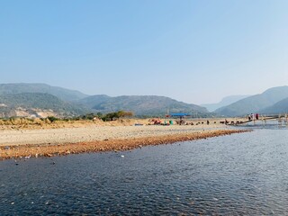 Scenic river flowing through a valley with people crossing a bamboo bridge