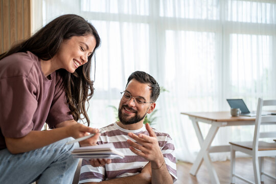 Young couple managing home finances and bills together at home - Powered by Adobe