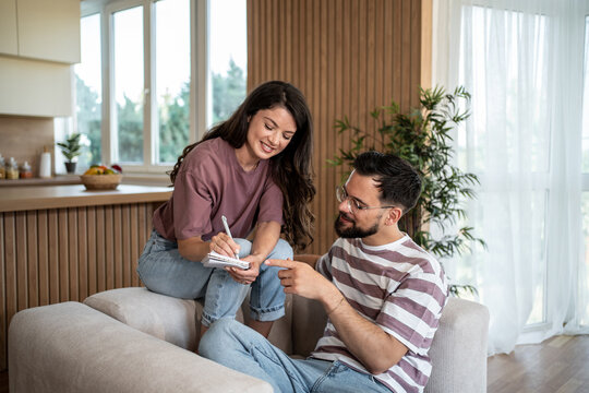 Young couple making a shopping list together at home
