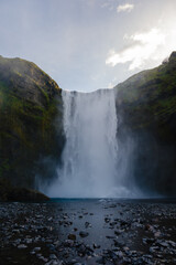 Majestic Skogafoss waterfall cascading down rugged cliffs in Icelandic summer sunlight