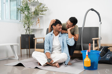Intimate cleaning moment. Two friends share laughter and affection while vacuuming.