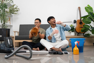 Fun Cleaning Session with Friends. Two young men enjoying music while cleaning their home.