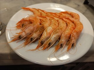 Fresh seafood delight: succulent cooked shrimp on a white plate for culinary inspiration